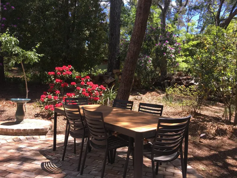 Garden dining table among flowering shrubs